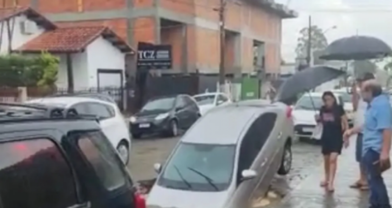 Carro é 'engolido' por cratera aberta por fortes chuvas em rua de SC
