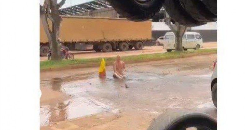 Homem toma banho em buraco de rua para protestar